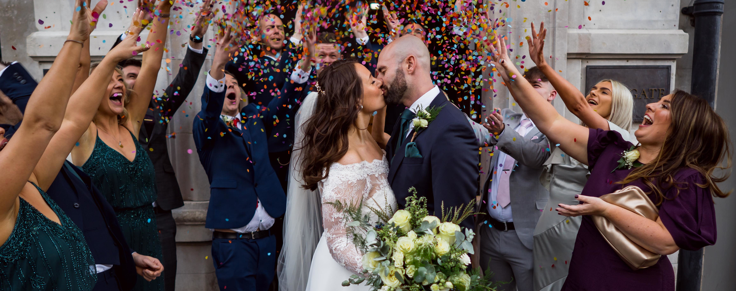 Bride and groom kiss with confetti